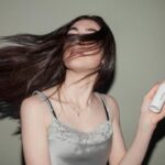 Mulher com cabelos lisos e brilhantes após aplicar dicas e truques para eliminar o frizz e manter os fios alinhados.