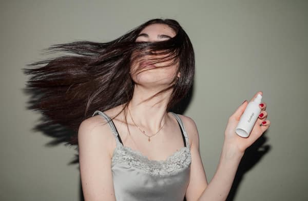 Mulher com cabelos lisos e brilhantes após aplicar dicas e truques para eliminar o frizz e manter os fios alinhados.